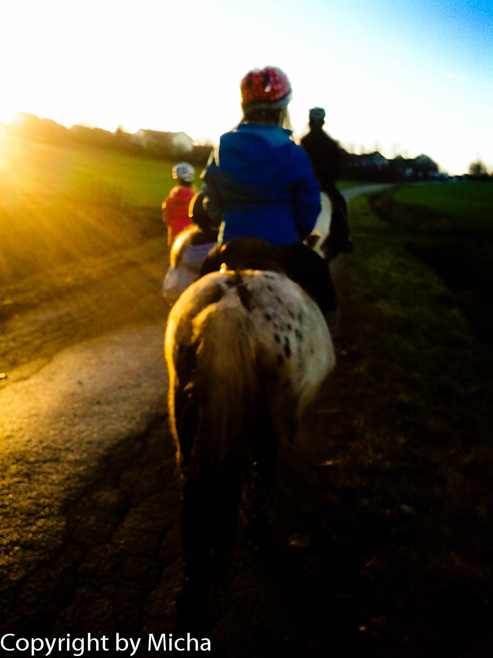 Ponykids reiten dem Sonnenuntergang entgegen.